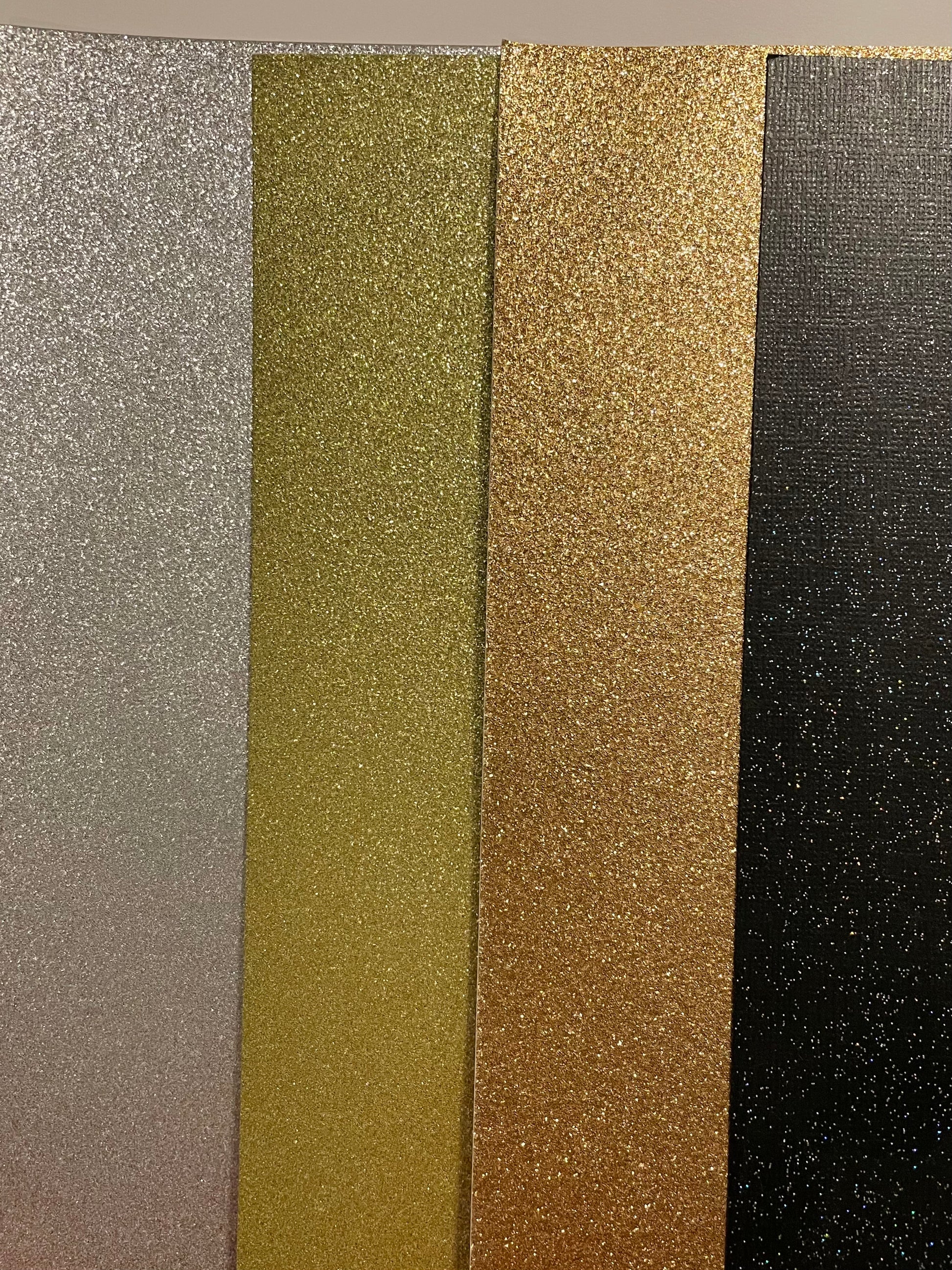 From left to right: silver, yellow gold, gold, black sparkle